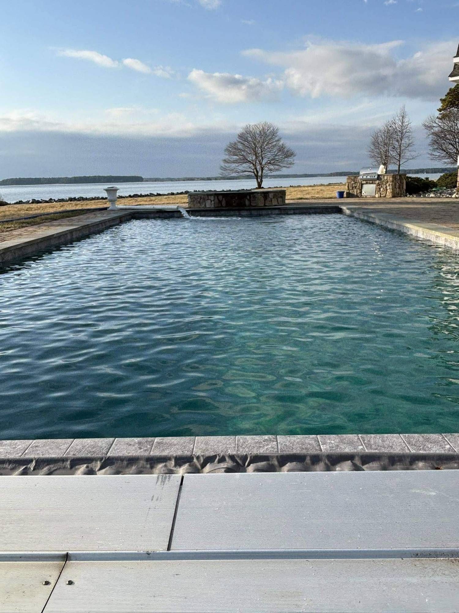 Infinity-edge pool filled and clear against the bay