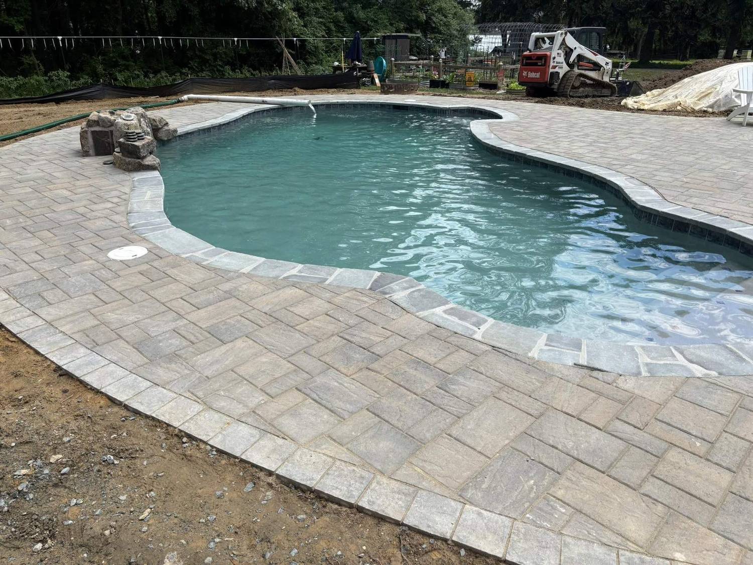Freeform paver pool filled with crystal clear water